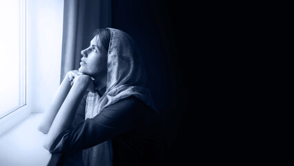 Girl praying by the window