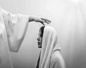 Blessing hand above the head of a woman in a headscarf