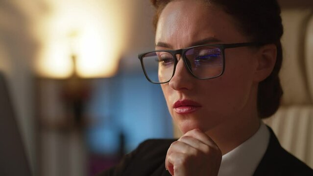 Close up shot of concentrated business woman. Concerned thoughtful caucasian lady working on laptop. Focused on tasks, employee works using notebook. Pensive lady in eyeglasses