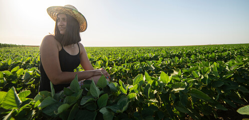 A young female farmer in a soybean field