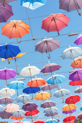 Fototapeta na wymiar Multicolored umbrellas hanging above street in Antalya in sunny day and blue sky. Book cover. Turkey (Turkiye)