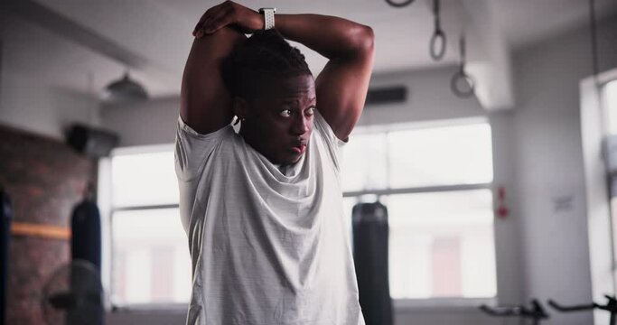 Black man, fitness and stretching at gym for workout, exercise or getting ready for indoor training. Active young African male person in body warm up, stretch or preparation for sports in health club