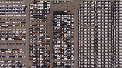 Top view of the electric vehicle transport yard and intercontinental shipping industry. - obrazy, fototapety, plakaty