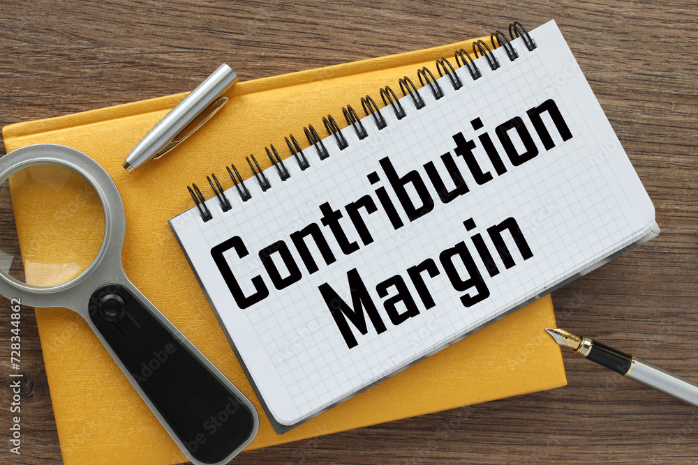 Aufkleber contribution margin yellow notepad with text on the page. white pen