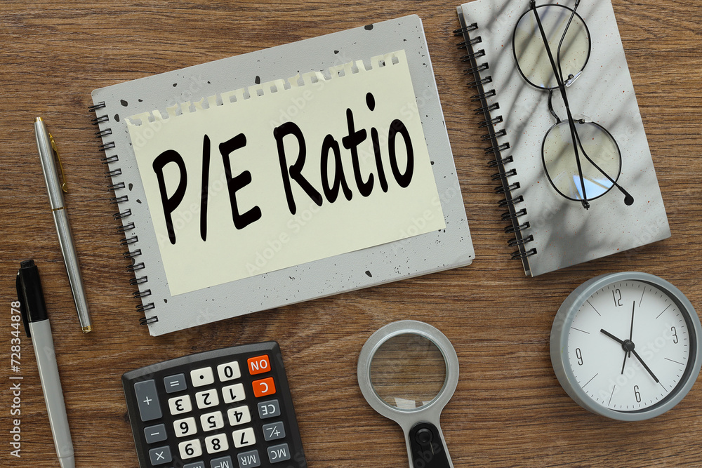 Poster price and earning . investment concept for p/e ratio. gray notepad with text on a torn page. a table