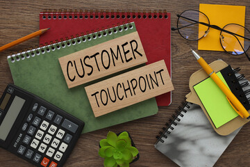 CUSTOMER TOUCHPOINT text on wooden boards on a notepad. work desk