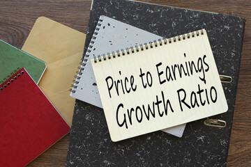 PEG Price to Earnings Growth ratio. text on a notepad. on a gray folder. different notepads on the work table