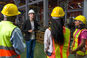 Warehouse safety meeting, people with hardhat. Industrial teamwork.