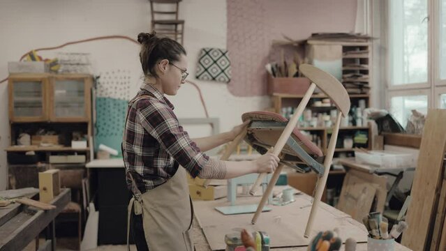 Female carpenter working in her workshop
