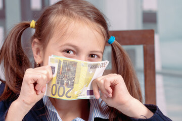 The smell of success and money. Young beautiful happy girl sniffs Euro bills money
