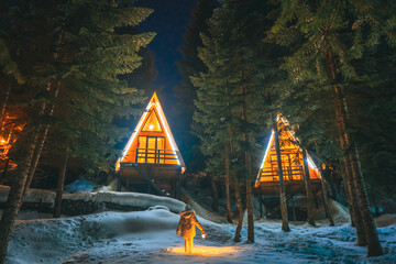 A triangular house in the middle of a snow-covered forest in winter in Georgia.