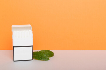 Pack of menthol cigarettes and fresh mint on colored table, Menthol cigarettes top view flat lay