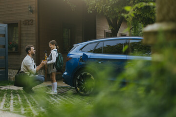 Father handing girl her science project for school science fair, robotic arm. Electric car is...