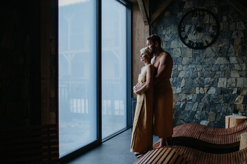Beautiful couple standing in hotel wellness, enjoying romantic weekend in spa. Concept of Valentine's Day.