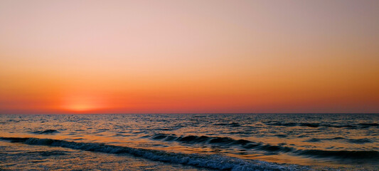 Beautiful sunset in the sea with calm waves