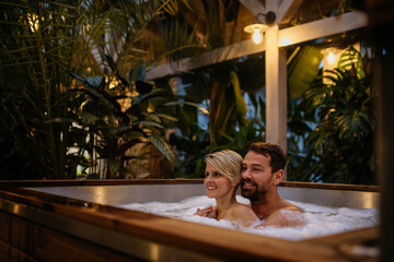 Beautiful mature couple relaxing in hot tub, enjoying romantic wellness weekend in spa. Concept of...