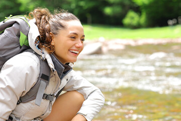 Happy hiker looks away in a riverside