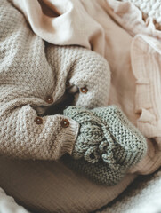 Knitted slippers and things for a newborn in the cradle
