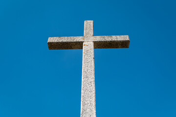 Escultura celestial: Uma cruz de granito erguida sob o manto azul do céu