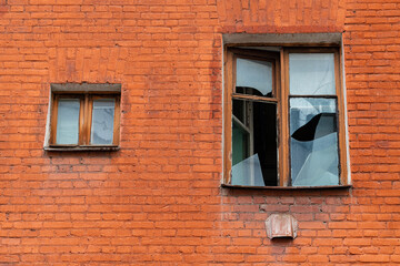 facade of an abandoned red brick house.