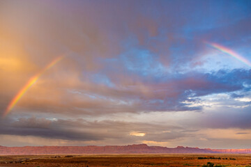 Echo Cliffs with dramatic sky at sunset near Great Canyon with rainbow