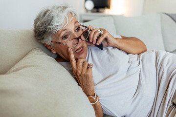 Senior, woman and phone call talking on sofa for communication, gossip or cell information. Old...