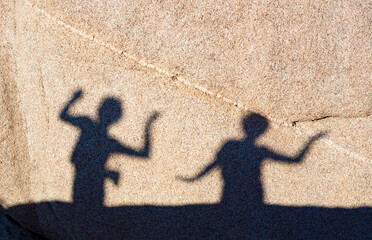 children playing with shadows on a rock