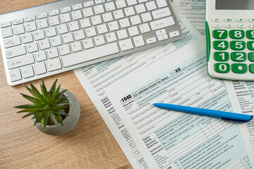 pen caluclator 1040 tax form on office desk, accounting concept