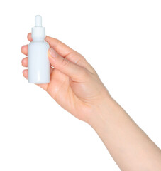 Woman hand holds a white cosmetic bottle, isolated on white background close-up, template for...