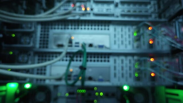 Close up blurred fiber optic and hub in server room. Motion camera.