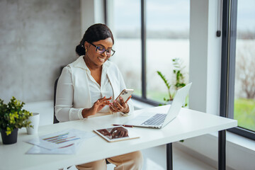 Business girl with phone typing during work break replying to email, sms message or networking via social media app. Communication, text conversation and black woman using smartphone for web search