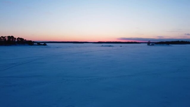 Aerial view risiing over snowy sea ice, vibrant winter dusk on the gulf of Finland