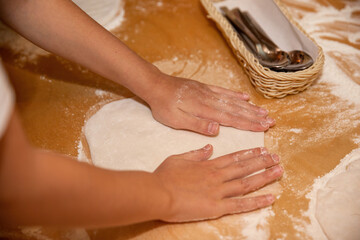 Making dough and pizza by a child.