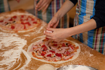 Making dough and pizza by a child.