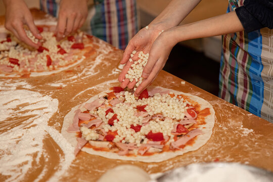 Making dough and pizza by a child.