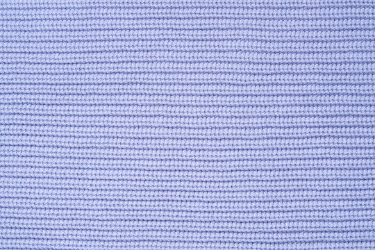 Blue knitted background from woollen yarns or cotton. Abstract texture of a knitted fabric surface.