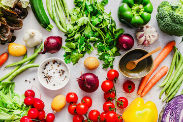 Frisches buntes Gemüse, Salz in einer Schüssel und Olivenöl au feinem grauen Tisch. Variation, gesunde Ernährung, Flat lay.
