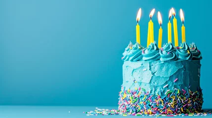 Fotobehang Birthday cake with blue frosting and yellow candles ready for a party, blue background © standret