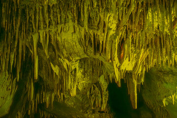Journey through a vibrant cave adorned with colorful walls, stalactites, and stalagmites, revealing...