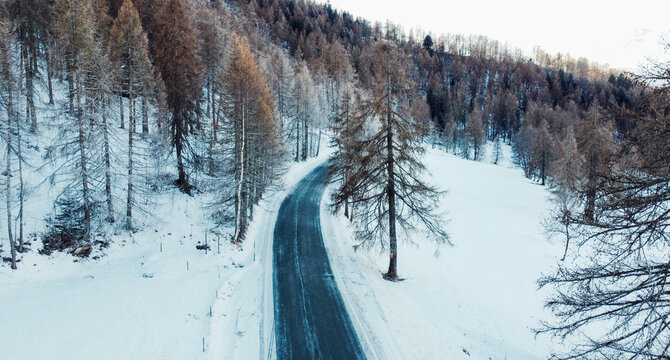 Aerial view of winding mountain road in winter.