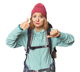 Middle-aged Caucasian woman with hiking gear showing thumbs up and thumbs down, difficult choose concept