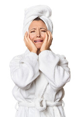 Caucasian woman in bathrobe and towel crying, unhappy with something, agony and confusion concept.