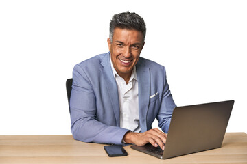 Middle-aged Hispanic man working on laptop in business suit