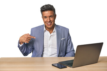 Elegant businessman at desk with laptop person pointing by hand to a shirt copy space, proud and confident