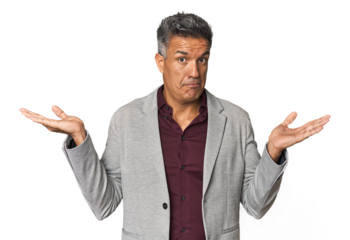 Middle-aged Latino man confused and doubtful shrugging shoulders to hold a copy space.