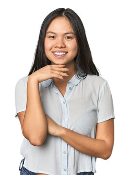 Young chinese woman isolated smiling happy and confident, touching chin with hand.
