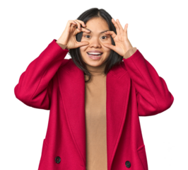 Young chinese woman isolated keeping eyes opened to find a success opportunity.