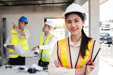 Portrait of a young Asian engineer standing with her arms crossed at a construction site. Portrait...