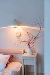 white bedroom with lamp and vase