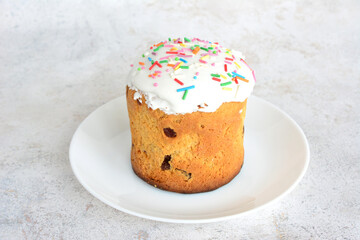 easter cake with white glazing and sugar sprinkles on white saucer